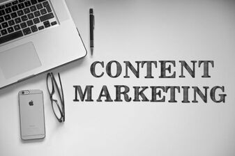 Laptop in der linken oberen Ecke, darunter ein Smartphone, rechts davon steht Content Marketing