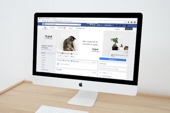 Apple Bildschirm auf einem hellen Holztisch, der ein Shop mit Dekoration und Lampenschirm mit Katze darauf zeigt