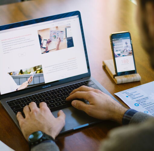 Website vom Freelancer erstellen lassen, Laptop und Smartphone auf den eine Webseite mit Bildern gezeigt wird