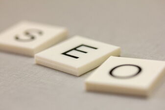 3 weiße Steine mit SEO Buchstaben in schwarz