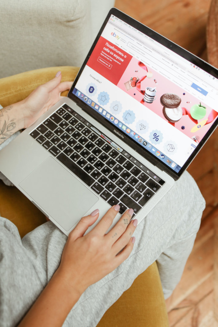Laptop Lebensmittelshop Seite Onlineshop erstellen lassen: Mann hat Laptop auf den Knien und sieht sich einen Shop an