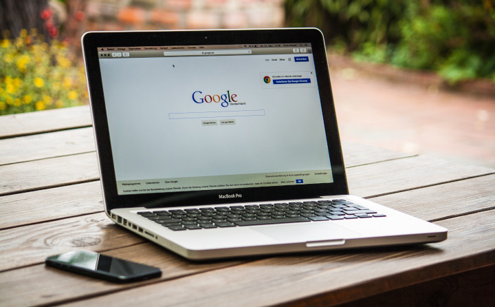 Notebook auf ein Holztisch geöffnet mit der Google Suchmaske
