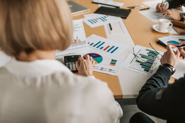 Team am Tisch Ausschnitt eines SEO-Teams am Tisch sitzend, auf dem Blätter mit Grafiken liegen